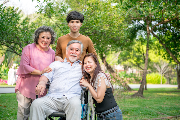 Senior man in wheel chair with his family in park