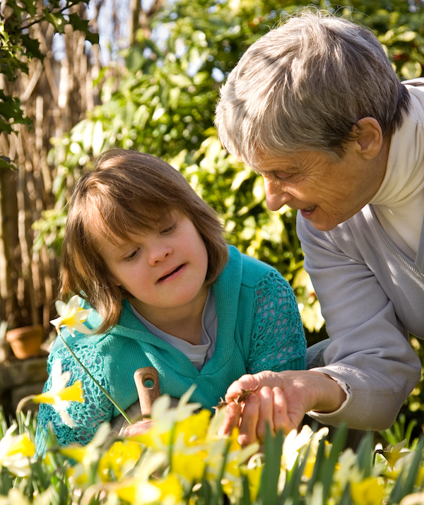Girl with down syndrome and her grandmother in a garden
